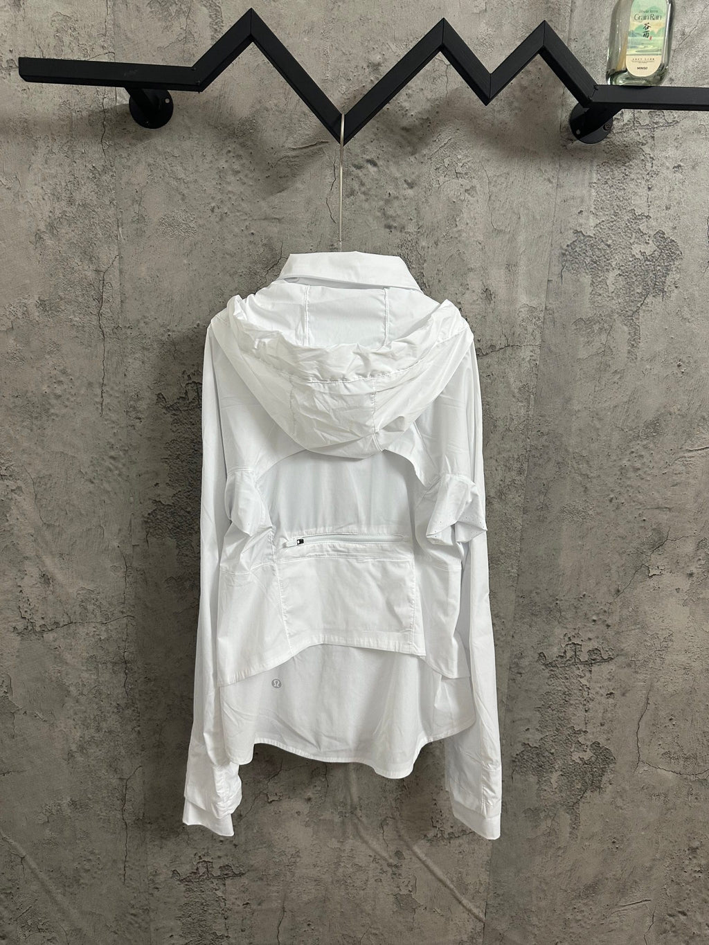 White hooded zip jacket, back view with gathered hood and wide hem