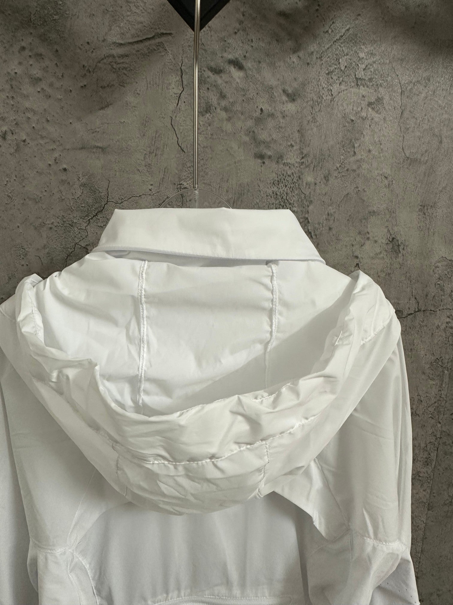 White hooded zip jacket, back view with draped hood detail
