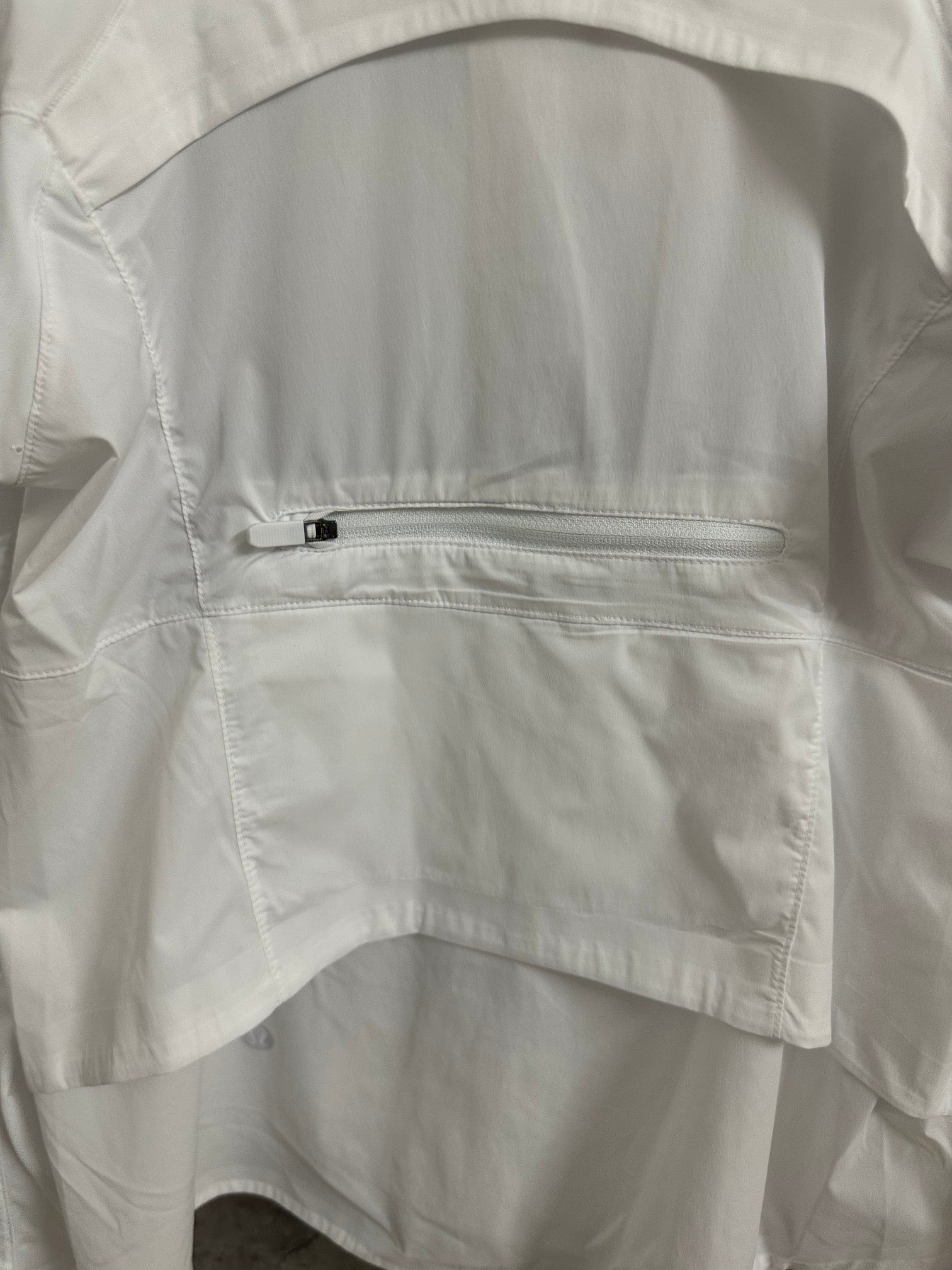 White jacket chest pocket with zipper and stitched panel detail