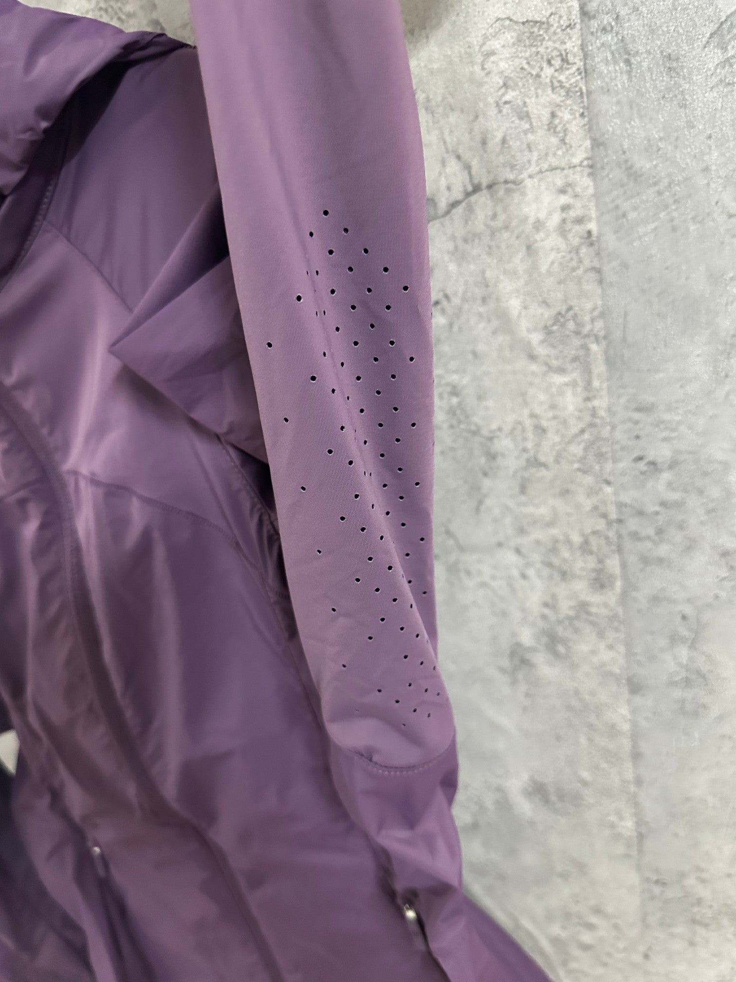 Purple perforated sleeve detail on hooded windbreaker jacket