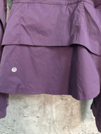 Purple windbreaker jacket hem with small logo badge