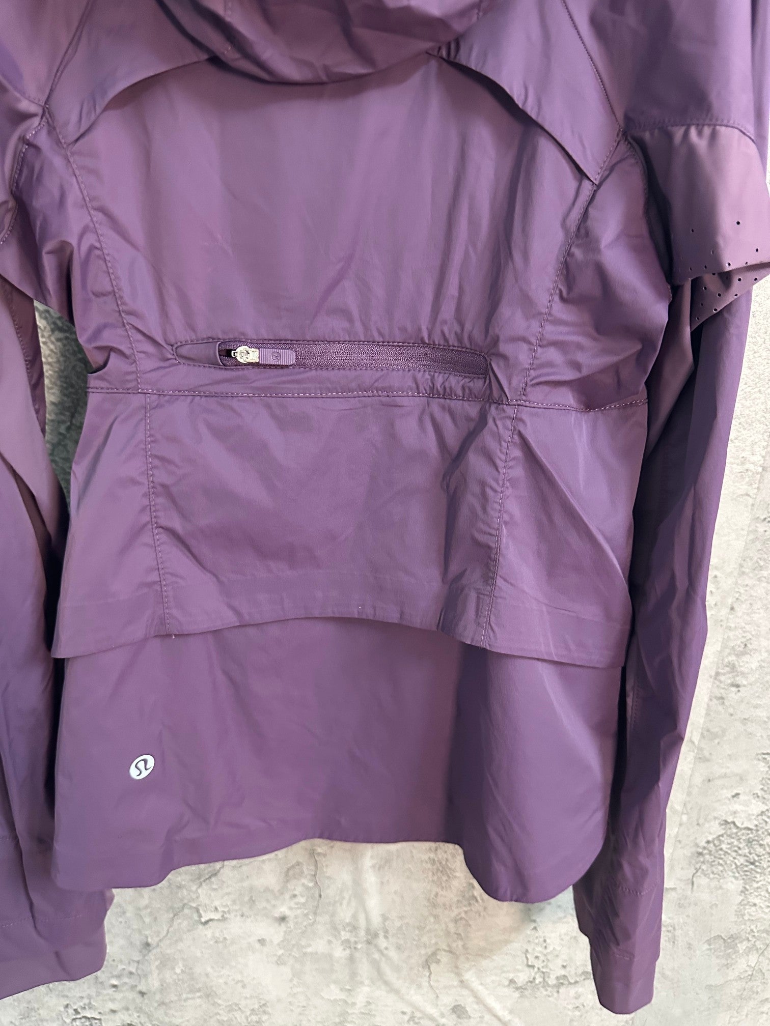Purple windbreaker jacket interior view with drawcord waist