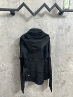 Hooded rain jacket back view with adjustable hem, dark color, long sleeves