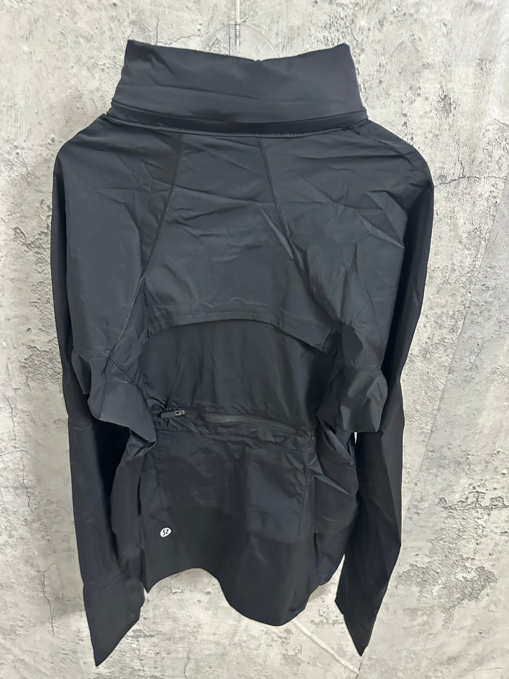 Hooded rain jacket back view with high collar and layered hood, dark color