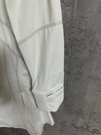 White jacket sleeve with stitched panel lines and elastic cuff hem