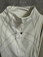 White jacket close-up with front zipper, stand collar, and stitched seam panels