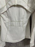White jacket front panel with snap-style pocket and diagonal stitched seams