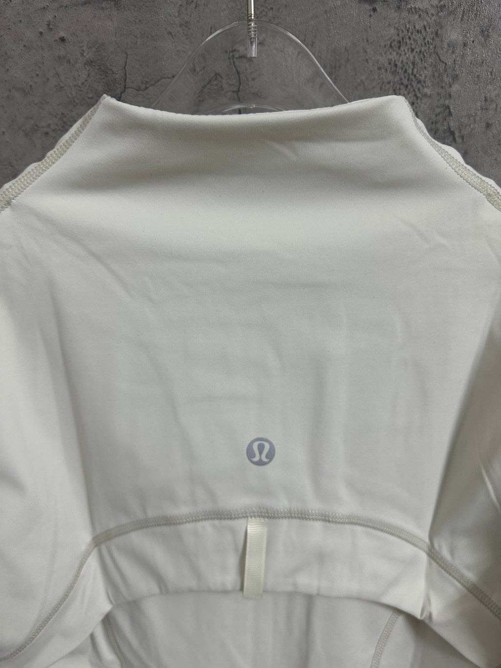 White jacket back with small emblem and curved waistband seam