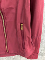 Burgundy jacket side view with zip pocket and ribbed cuff detail