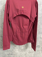 Burgundy jacket back view with gathering at yoke and small gold emblem