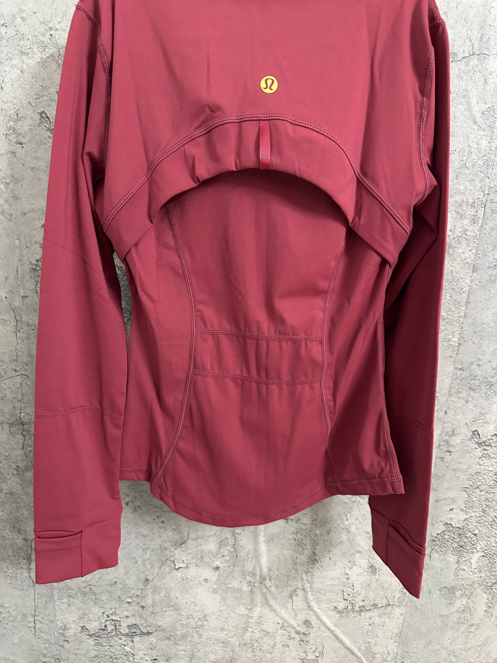 Burgundy jacket back view with gold emblem and panel seam at yoke
