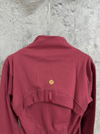 Burgundy jacket back with stand collar and small gold logo at center