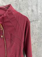 Burgundy jacket shoulder and sleeve with stitched panel lines