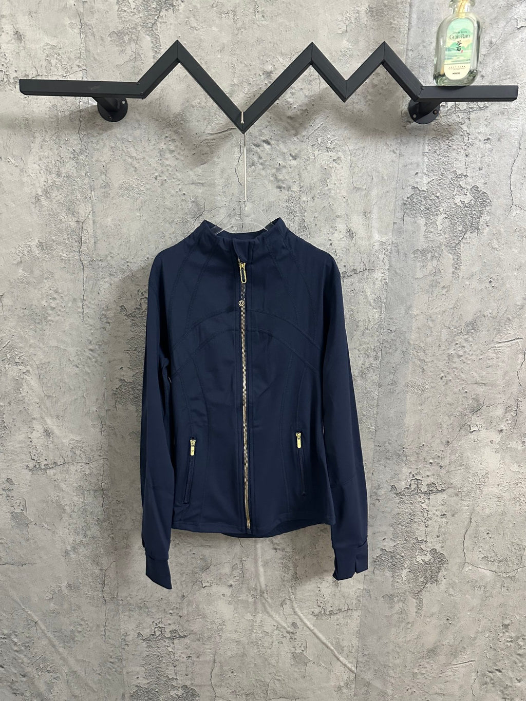 Navy zip-up jacket with stand collar, full front zipper, and gold zipper pulls