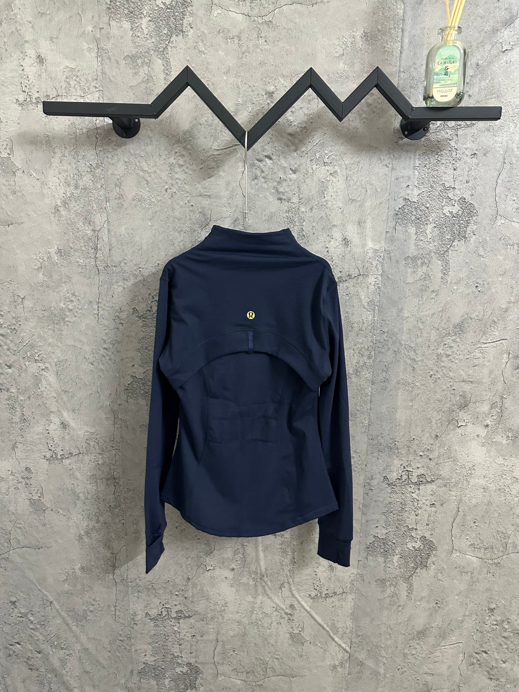 Navy jacket with stand collar and full-zip back view, gold zipper pull at center