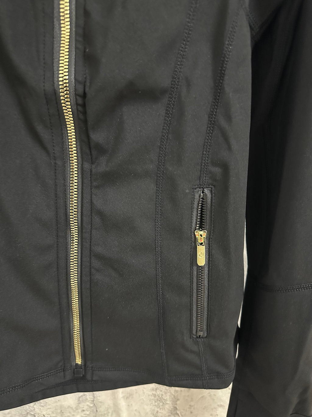 Black jacket close-up of front zipper and small chest zip pocket
