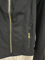 Black jacket with gold-tone front zipper and small chest/side zip