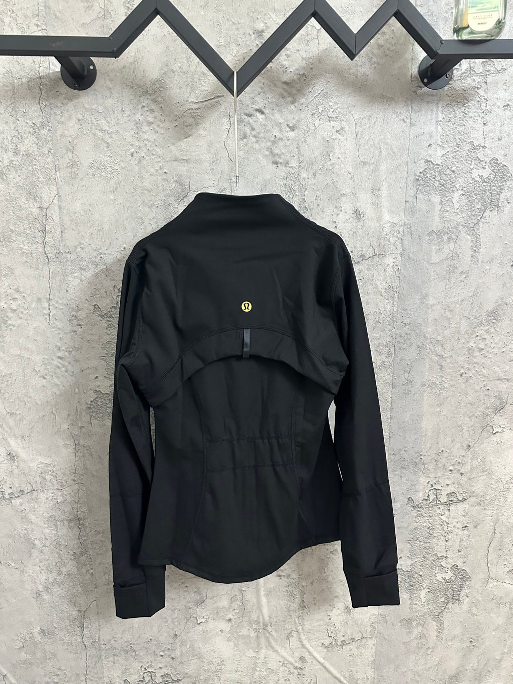 Black zip-front jacket, back view with gold-tone logo at upper back