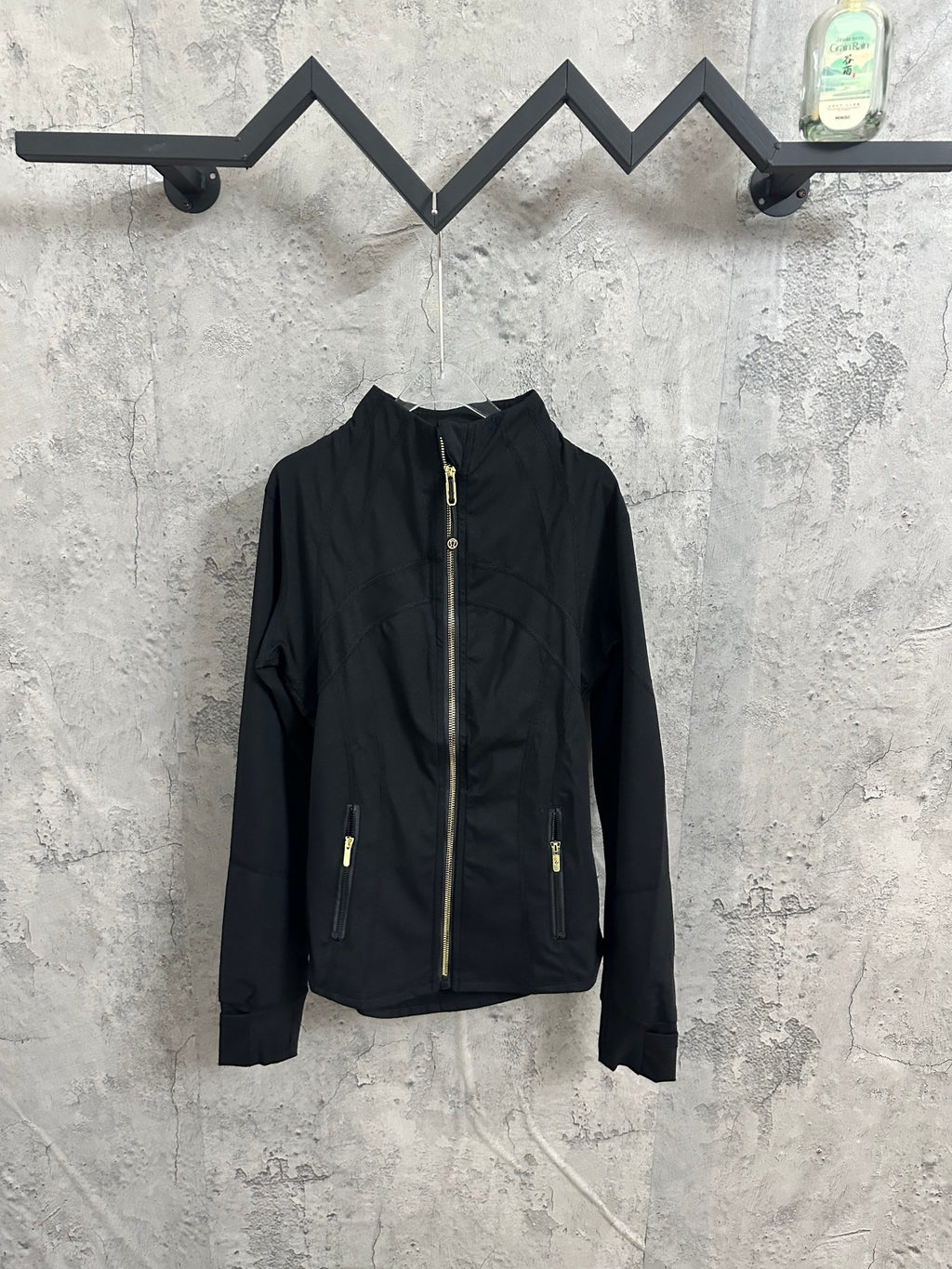Black zip-front jacket with stand collar and gold-tone zipper pulls