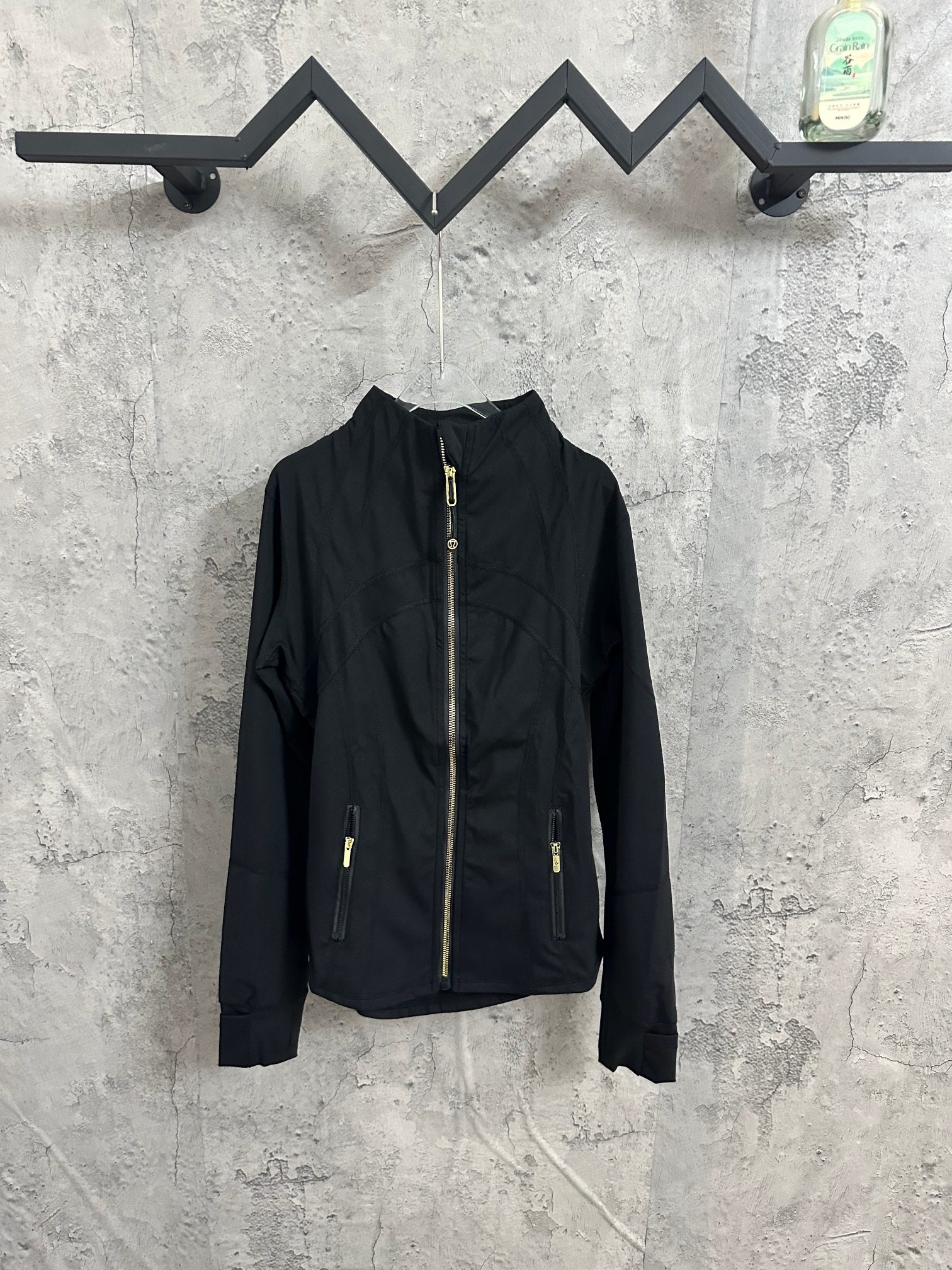 Black zip-front jacket with stand collar and gold-tone zipper pulls