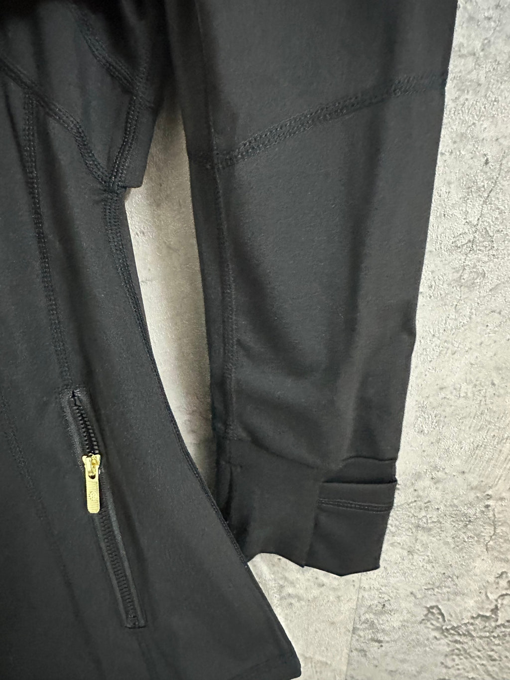 Black jacket with ribbed cuffs and partial side zipper pocket