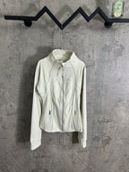 Light white zip-up jacket with stand collar, gold front zipper, and side zip pockets.