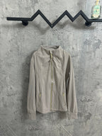 Light beige zip-front jacket with stand collar and long sleeves, logo near chest
