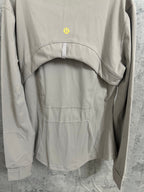 Beige jacket back panel with small gold logo and stitched yoke seam detail