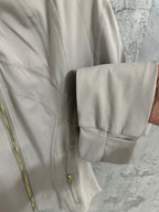 Beige jacket cuff and hem with button strap detail and stitched pocket flap