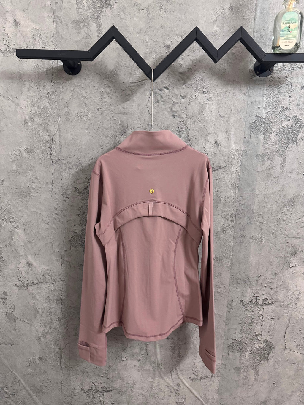 Dusty pink jacket with zip closure, stand collar, and back yoke seams