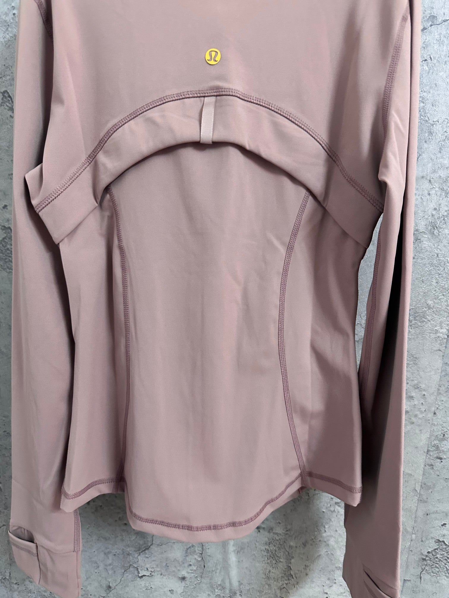 Dusty pink jacket back with arched yoke panel and curved seam details