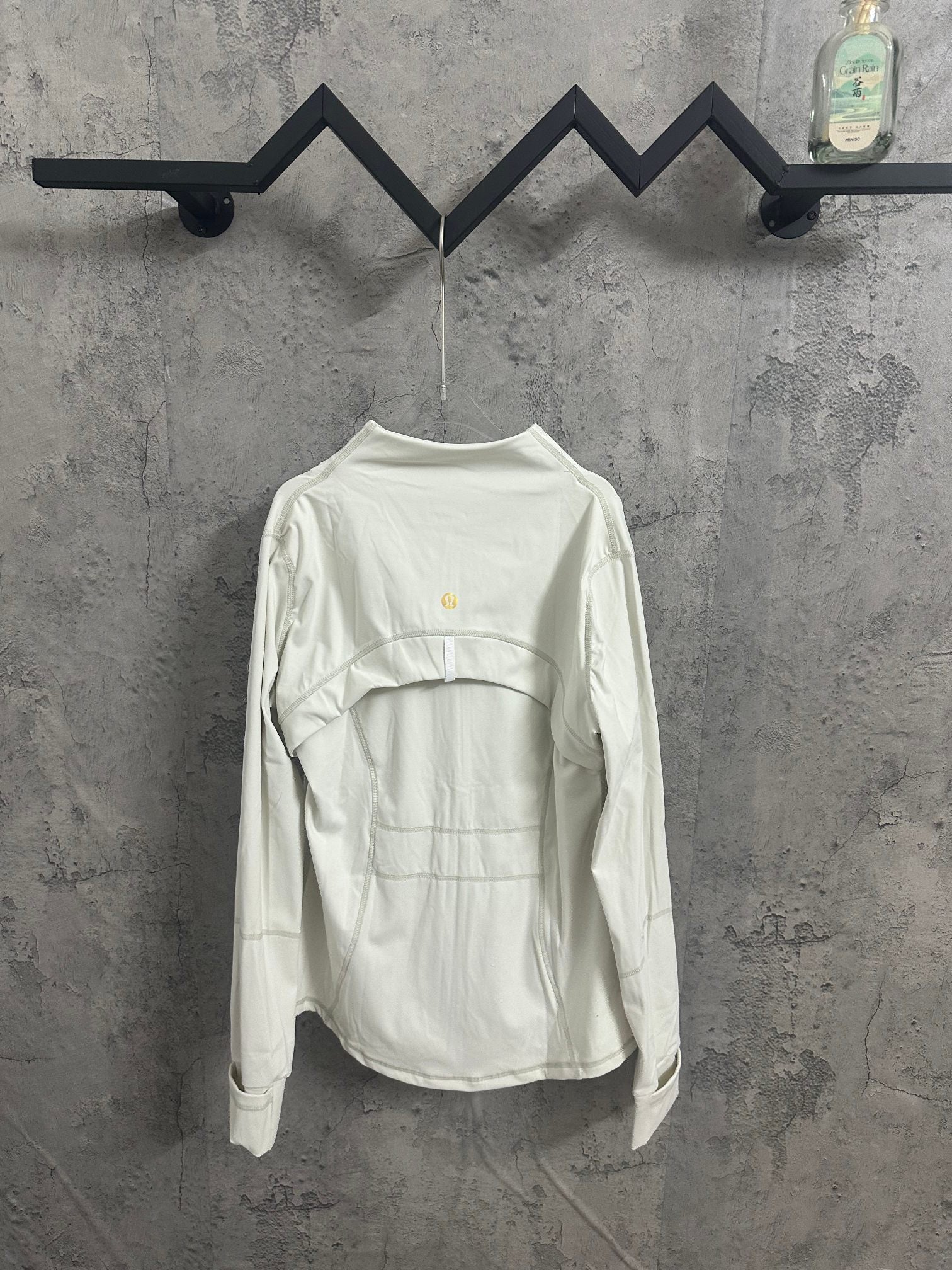 White zip-up jacket, back view, stand collar and gold-tone zipper pulls