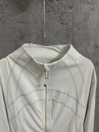 White zip-up jacket close-up, stand collar with gold-tone zipper and trim