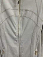 White zip-up jacket close-up, center zipper with gold-tone hardware details