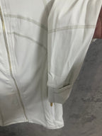 White zip-up jacket sleeve and cuff with gold-tone zipper pull detail
