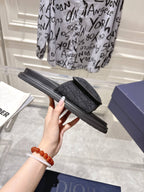 Black slide sandals showing side view with textured strap and ribbed sole
