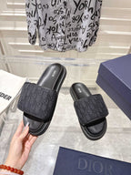 Black slide sandals with monogram-textured strap and contoured footbed
