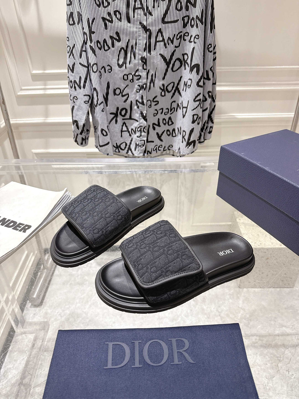 Pair of black Dior slide sandals with patterned front strap and thick sole