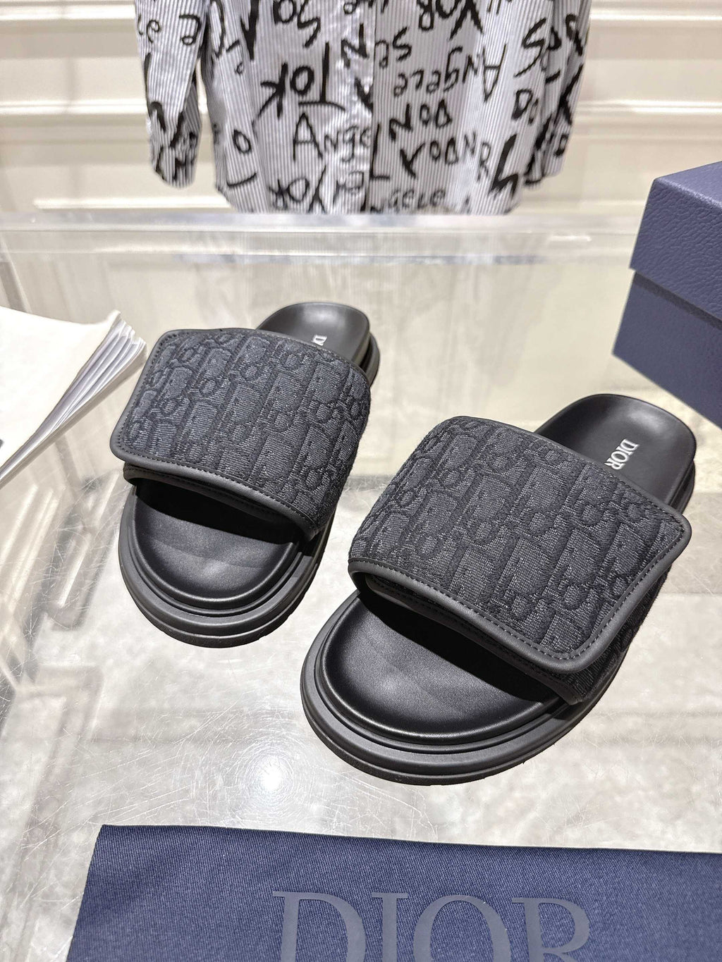 Black slide sandals with embossed monogram strap and chunky stacked sole