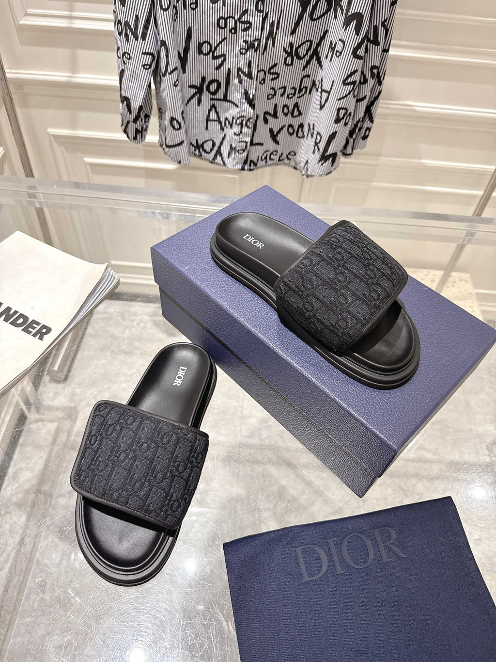 Black Dior slide sandals with embossed monogram strap and padded footbed