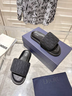 Black Dior slide sandals with embossed monogram strap and padded footbed