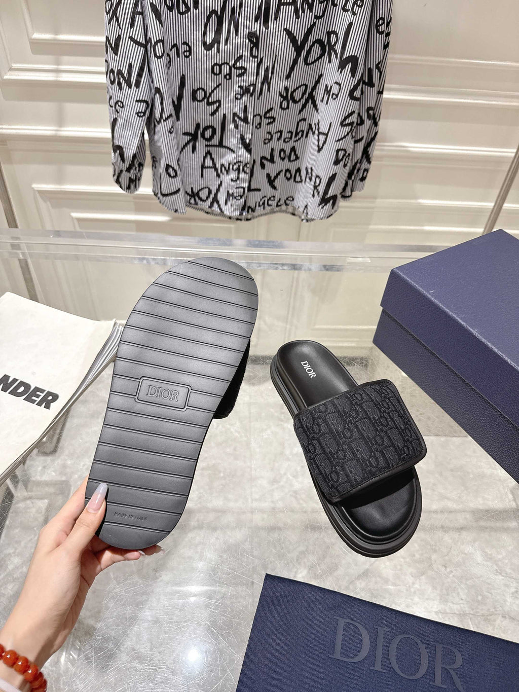 Black slide sandals outsole view with molded tread and monogram strap top