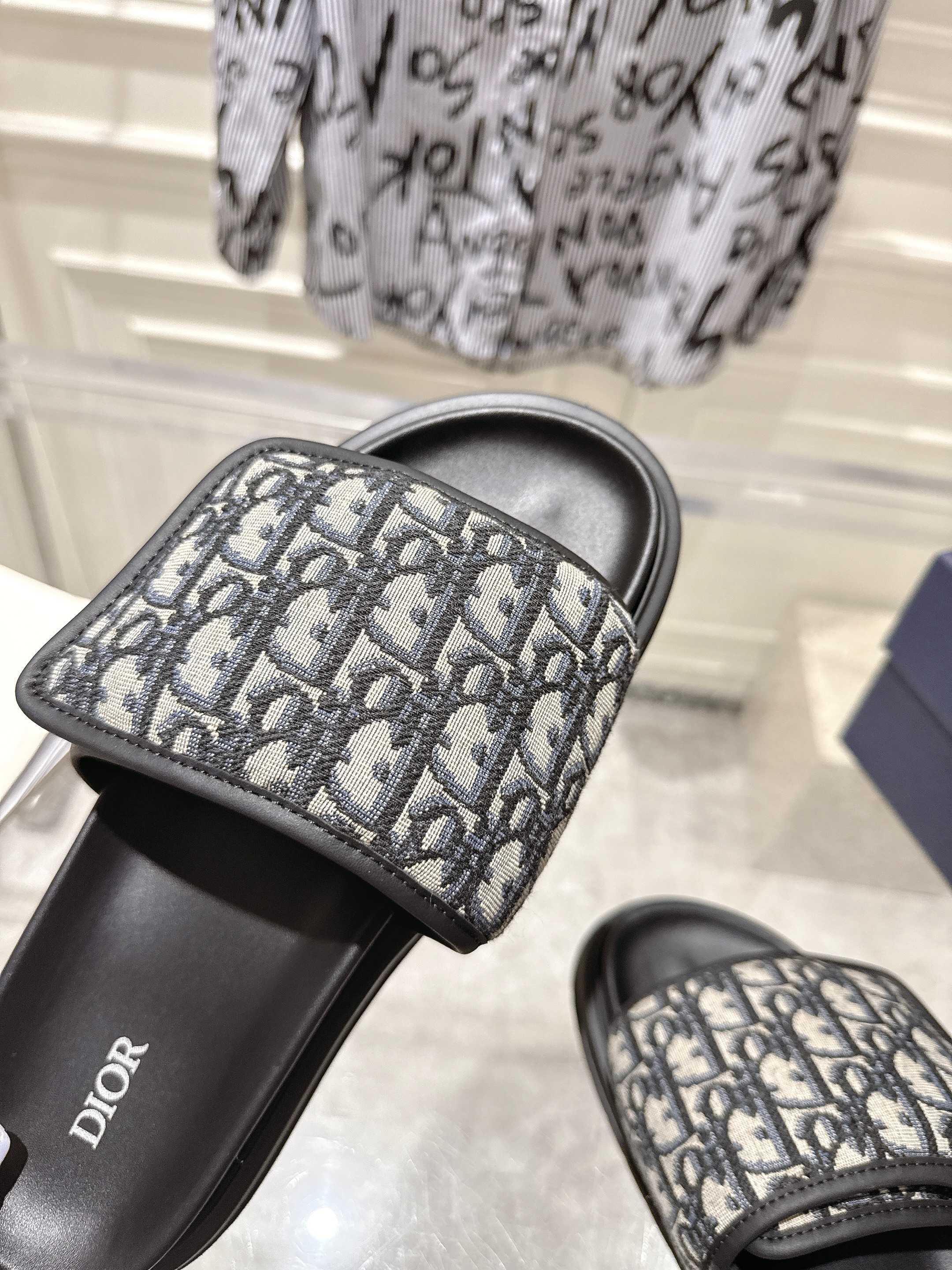Dior slide sandals close-up; gray Dior-oblique strap detail with black trim