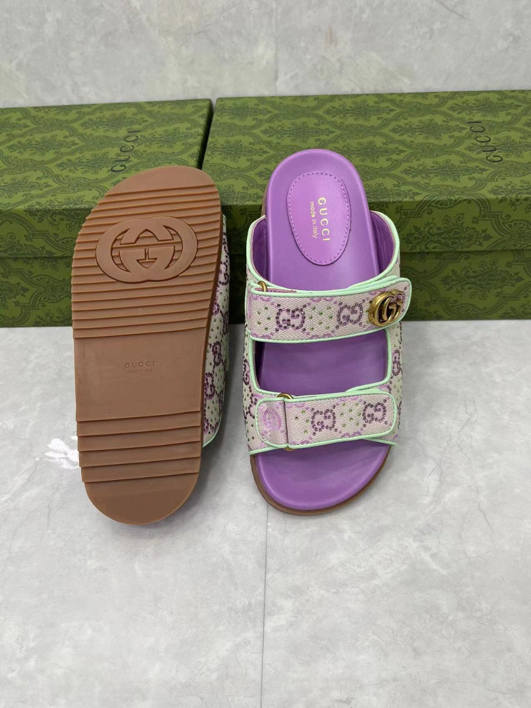 Gucci lilac slide sandals with textured rubber outsole and gold buckle, open toe.