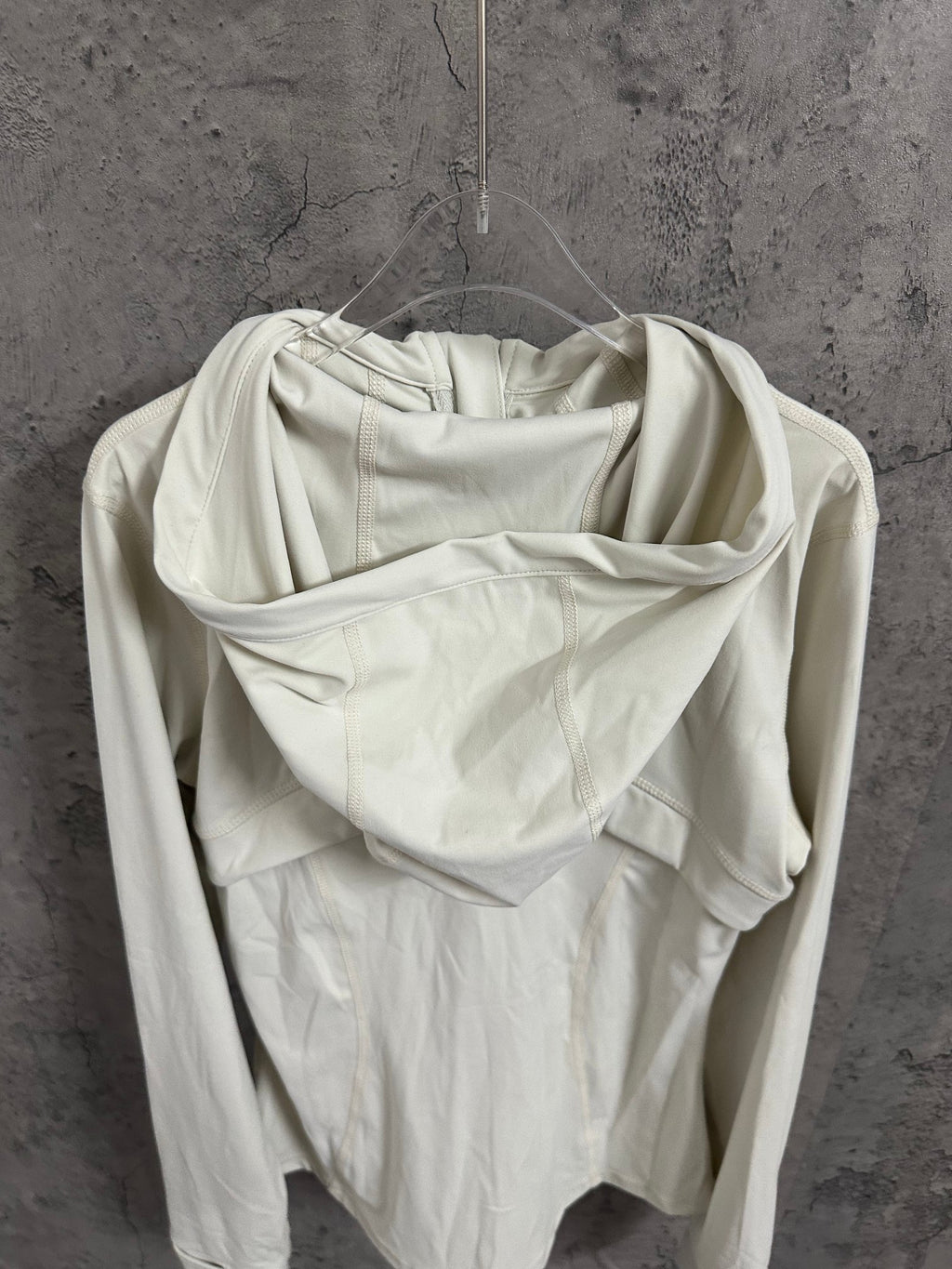 Cream hooded jacket back view with draped hood and long sleeves