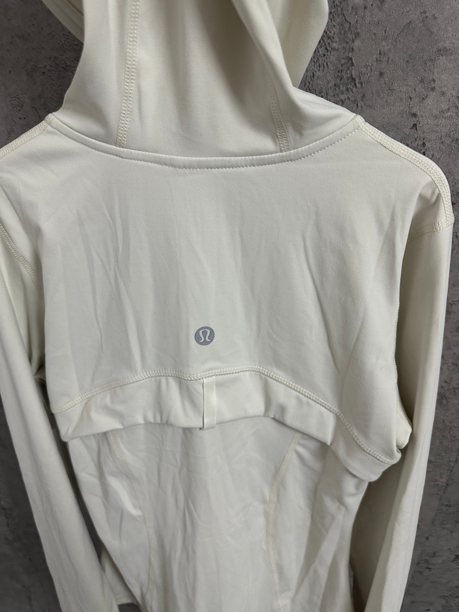 White hoodie back view with small logo near center and crew-style neckline seam.
