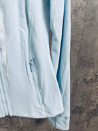 Light blue zip-up jacket sleeve and front zipper pocket detail