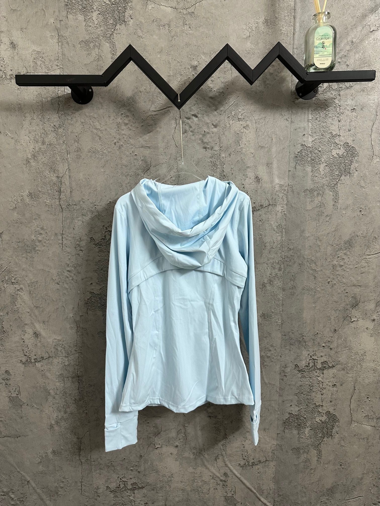 Light blue hooded zip jacket with relaxed fit and drawstring hem