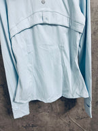 Light blue hooded zip jacket back hem with gathered fabric and curved seam