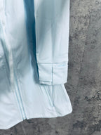 Light blue jacket with elastic cuffs and front zipper seam detail